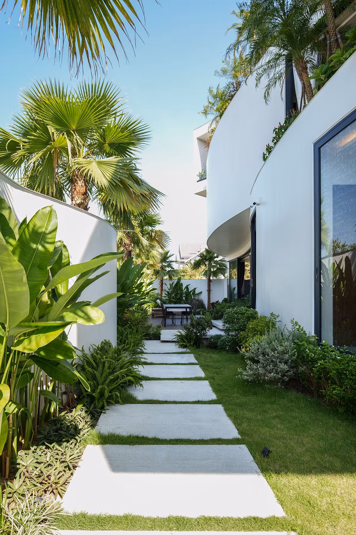 Để tránh ảnh hưởng trực tiếp bởi các luồng khí nóng trong mùa hè đồng thời giảm diện tích bê tông hoá, bao quanh nhà là khoảng sân nhiều cây xanh.