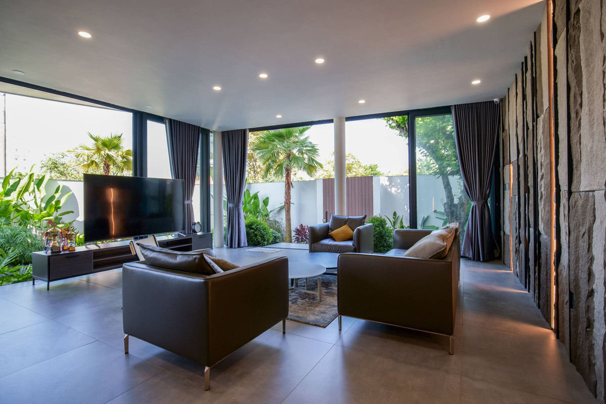 Phòng khách thoáng đãng nhờ hệ thống cửa kính lớn.