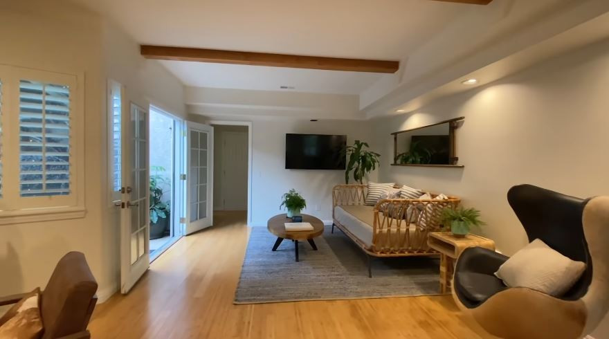 Trần phòng khách đặt những thanh gỗ thô lớn để tạo không gian vừa thoáng vừa ấm cúng, đồng thời tạo điểm nhấn thay vì tường trắng như trước.