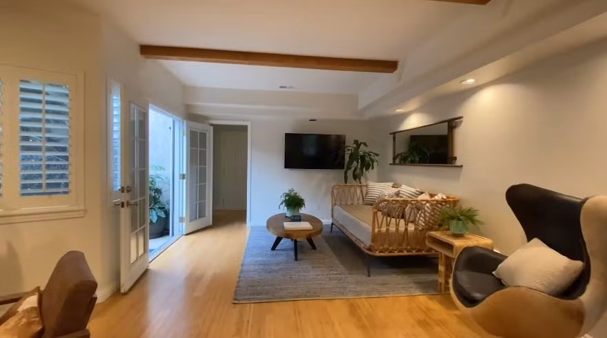 Trần phòng khách đặt những thanh gỗ thô lớn để tạo không gian vừa thoáng vừa ấm cúng, đồng thời tạo điểm nhấn thay vì tường trắng như trước.