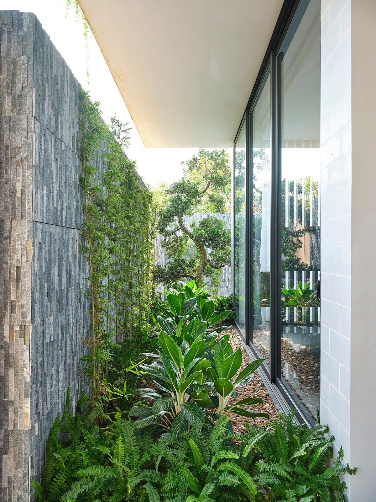 Không gian sân vườn bao quanh tầng 1 giống như khoảng đệm lọc tiếng ồn và khói bụi.