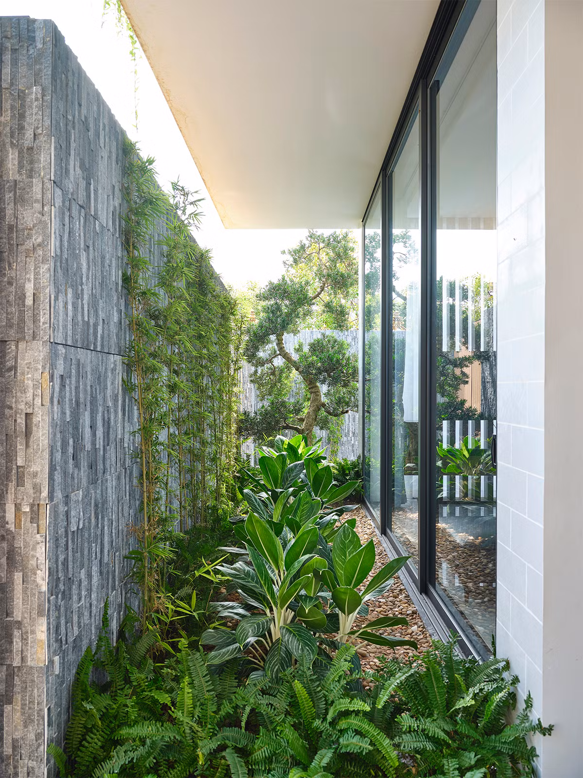 Không gian sân vườn bao quanh tầng 1 giống như khoảng đệm lọc tiếng ồn và khói bụi.