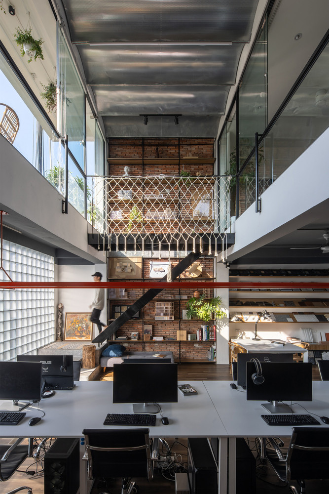 Điểm nhấn trong căn nhà là hệ thống thang thép chạy dọc theo một hệ giá kệ cao 2 tầng.