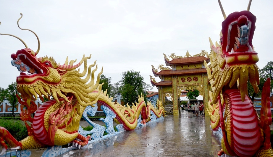 Cổng vào nhà thờ là cặp rồng lớn uy nghi, uốn lượn tạo thành cây cầu bắc qua con rạch. Ảnh: Zing