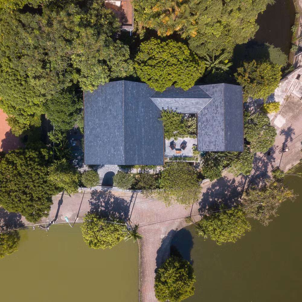 Ngôi nhà mái dốc màu xám được thiết kế theo hình khối chữ U.