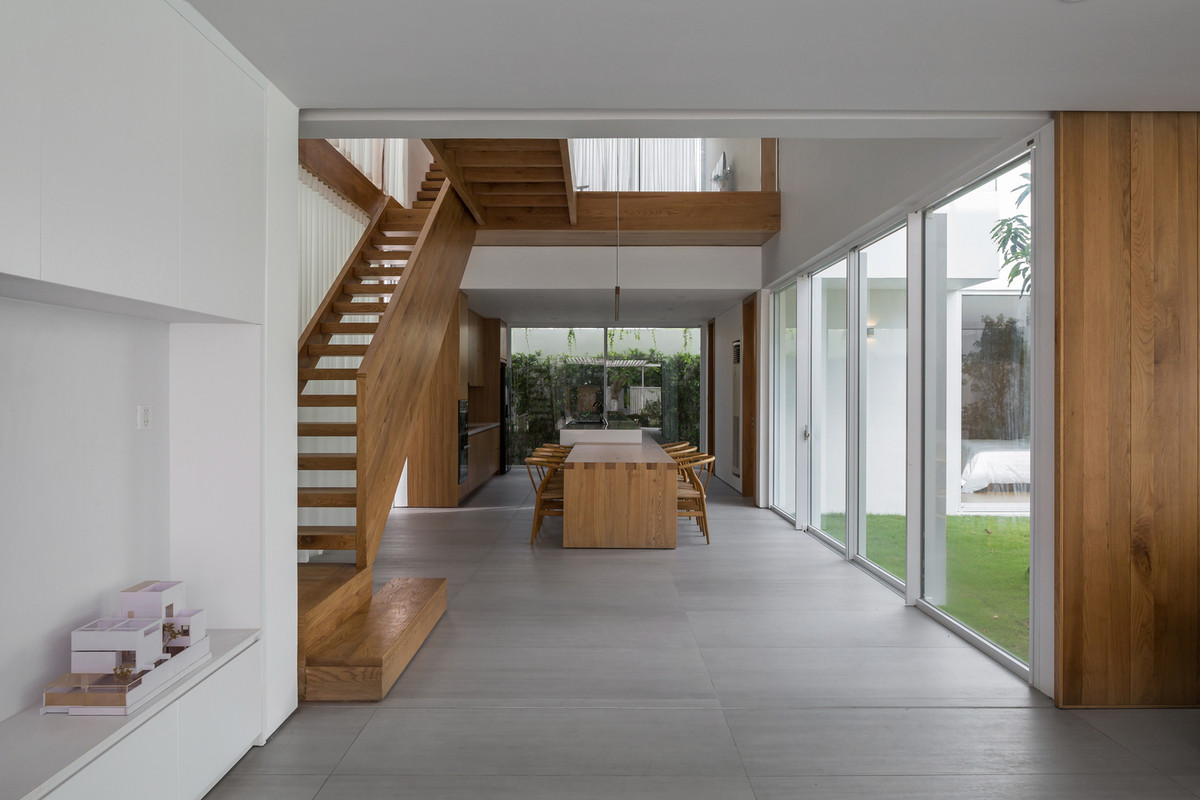 Phòng ăn với khoảng giếng trời và hành lang gỗ nối phía trên giúp tăng cường sự tương tác.