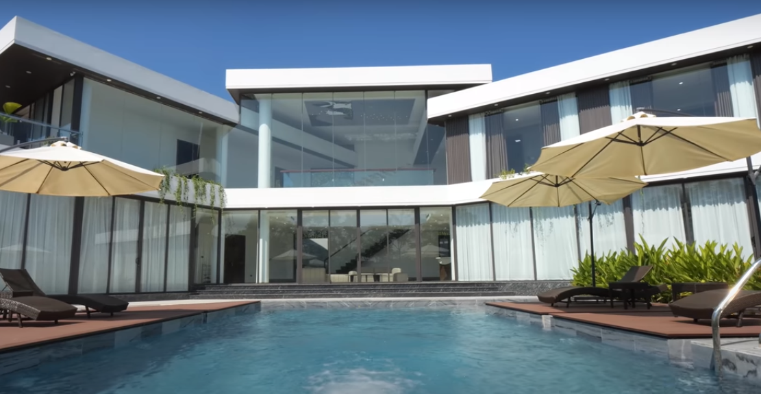  Biệt thự nghỉ dưỡng được thiết kế theo phong cách hiện đại với tông màu trắng và đen với điểm nhấn là mảng tường xung quanh hoàn toàn bằng kính.