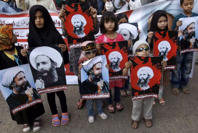 Nhiều trẻ em Hồi giáo Shiite mang theo bức chân dung giáo sĩ Nimr al-Nimr trong một cuộc biểu tình ở Karachi, Pakistan.