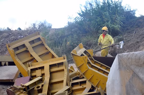 Nam công nhân làm nhiệm vụ bảo vệ tài sản trước cửa hầm thủy điện Đạ Dâng.