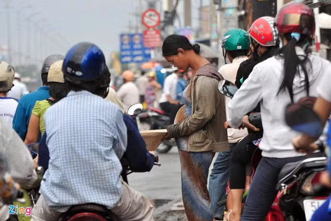 Còn đây là một cô gái mới khoảng 25 tuổi nhưng rất "nổi tiếng" trong giới ăn xin ở TP.HCM. Cô mang một bụng bầu giả, thường đứng tại các giao lộ. Cô gái này "mang bầu" đã... 3 năm vẫn chưa đẻ và nghiện ma tuý nặng. Mỗi khi xin được nhiều tiền, cô thường đón xe buýt về khu vực quận 8 mua ma tuý, hết tiền thì đi xin tiếp.