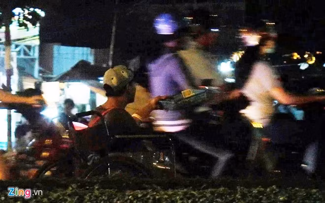 Một thanh niên tàn tật khoảng 25 tuổi ăn xin tại giao lộ Nguyễn Văn Linh - đường dẫn cầu Tân Thuận. Anh cho xe chạy tới chạy lui, len lỏi vào cả dòng xe cộ lưu thông để xin tiền. Xin được nhiều, anh sẽ gom lại đưa cho người đàn ông ngồi gần đó, chỉ để lại vài ngàn đồng tiền lẻ. Hai người hoạt động tại khu vực này từ chiều tối đến khuya, kiếm khá.