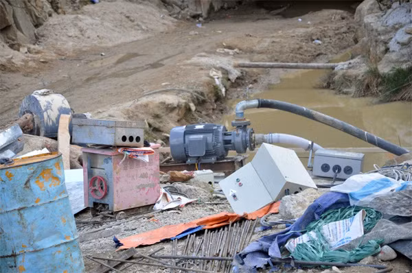 Nam công nhân tranh thủ mắc điện thắp sáng trước khi trời tối.