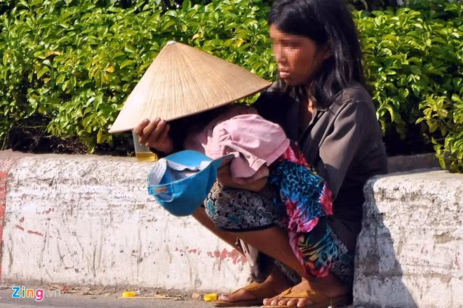 Hơn 2 năm nay, người phụ nữ này thường bế một bé gái phơi giữa nắng, mưa. Địa bàn hoạt động của người này trải dài khắp các quận Tân Bình, Tân Phú, Gò Vấp, quận 12.