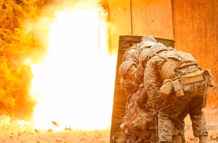 Các binh sĩ Đại đội đột kích cơ động, Tiểu đoàn Công binh chiến đấu 2, Sư đoàn Thủy quân Lục chiến 2 đứng núp sau tấm chắn đạn khi thực hiện vụ nổ phá cửa căn nhà kiên cố trong cuộc diễn tập ở trại Lejeune.