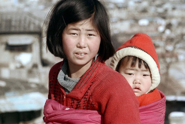 Hình ảnh chị địu em đi chơi khi bố mẹ bận bịu công việc.