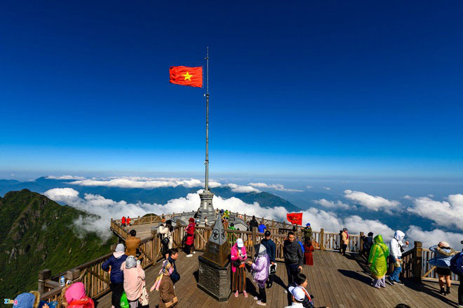 Fansipan là núi cao nhất Việt Nam với 3.143 m. Ngọn núi thuộc dãy Hoàng Liên Sơn này còn được mệnh danh là "Nóc nhà Đông Dương". Những ngày đầu năm, nhiệt độ nơi đây ở mức thấp, kèm theo mưa và gió lạnh, song du khách vẫn đổ về chờ nhiều tiếng để đi cáp treo lên đỉnh Fansipan và mong được ngắm tuyết rơi. Ảnh: Việt Linh.