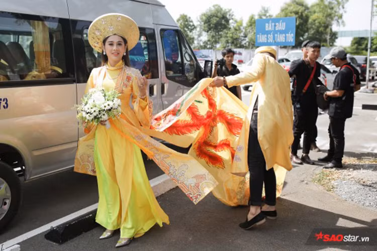 Bước xuống xe rước dâu, Lâm Khánh Chi gây chú ý khi diện áo dài cầu kỳ với phần tà quét đất. Ảnh: Khám phá