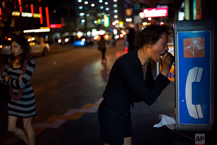 Một phụ nữ tâm thần gào khóc trong lúc nói chuyện điện thoại. Theo nhiếp ảnh gia, đây là Kara Miller, một cư dân quen thuộc của khu Skid Row. Miller thường lang thang trên khắp các đường phố ở Los Angeles và thỉnh thoảng lại gào thét hoặc nói tục như thể gặp phải một con quỷ nào đó.