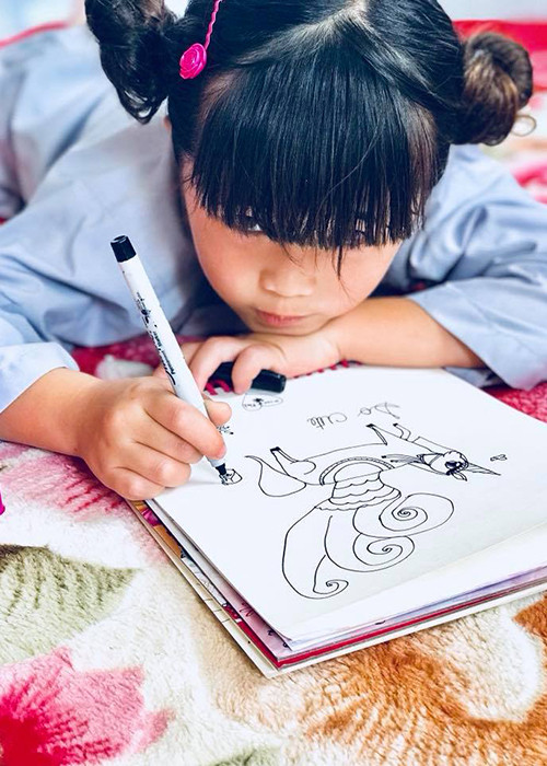 Con gái của danh hài Thúy Nga say mê vẽ tranh khi cùng mẹ đi chùa.