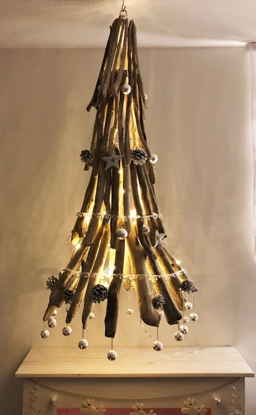 Cây thông Noel phiên bảng đèn trùm được kết từ những thanh gỗ.