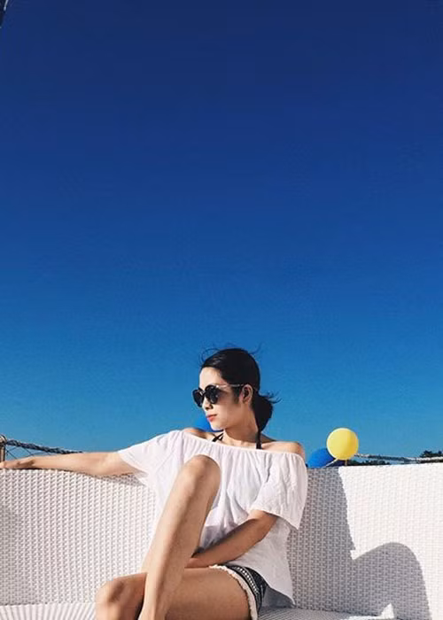 Hà Tăng diện áo trắng trễ vai kết hợp với quần short họa tiết trong chuyến đi biển ở Philippines vào tháng 4/2016.