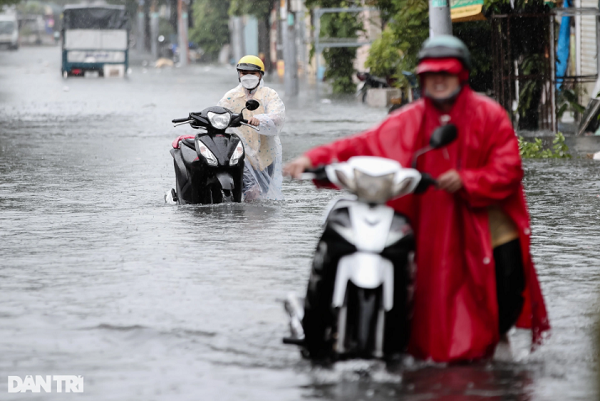 Một số người dân cố di chuyển qua đoạn ngập khiến xe chết máy phải dẫn bộ.