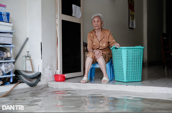 Căn phòng khách của gia đình bà Nguyễn Thị Vương (94 tuổi) cũng sắp bị nước tràn vào."Tôi ở đây cả mấy chục năm rồi, khu vực này cứ mưa là sẽ ngập. Có hôm mưa lớn, nước tràn vào nhà, nhiều đồ đạc trong nhà tôi bị hỏng do ngâm nước", bà Vương chia sẻ.