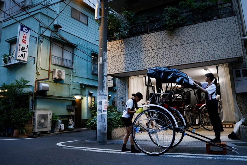 Pullers Akina Suzuki (trái) và Misato Otoshi, 30 tuổi, vệ sinh chiếc xe kéo của họ sau giờ làm việc tại một gara ở quận Asakusa, Tokyo, Nhật Bản. Ảnh: Reuters.