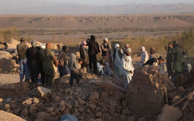 Vào lúc màn đêm buông xuống tại làng Sarboland, huyện Zinda Jan, tỉnh Herat, hàng chục ngôi nhà bị san phẳng gần tâm chấn của trận động đất. Nhiều người đàn ông phải dùng xẻng đào từ đống gạch vụn, trong khi phụ nữ và trẻ em chờ đợi ngoài trời, bên cạnh là ngôi nhà không còn gì.