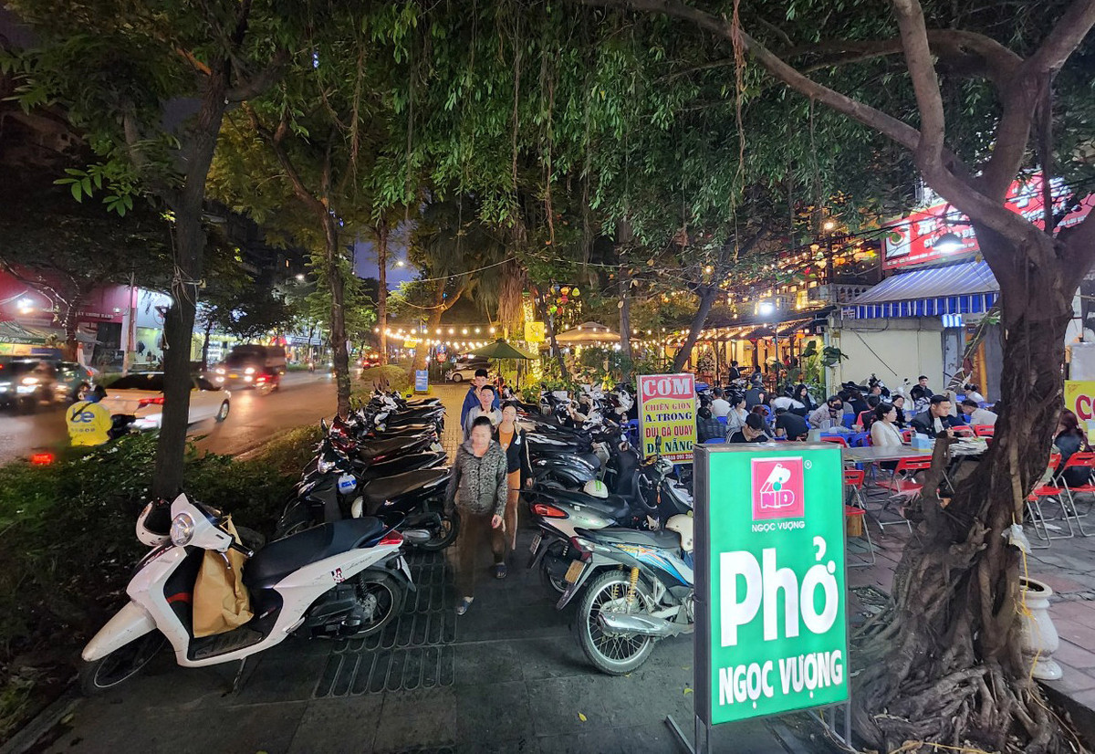 Dù vỉa hè trên phố Huỳnh Thúc Kháng (quận Đống Đa) rộng khoảng 3m, nhưng bị hàng quán lấn chiếm gần hết, buộc người đi bộ phải luồn lách qua những hàng xe.