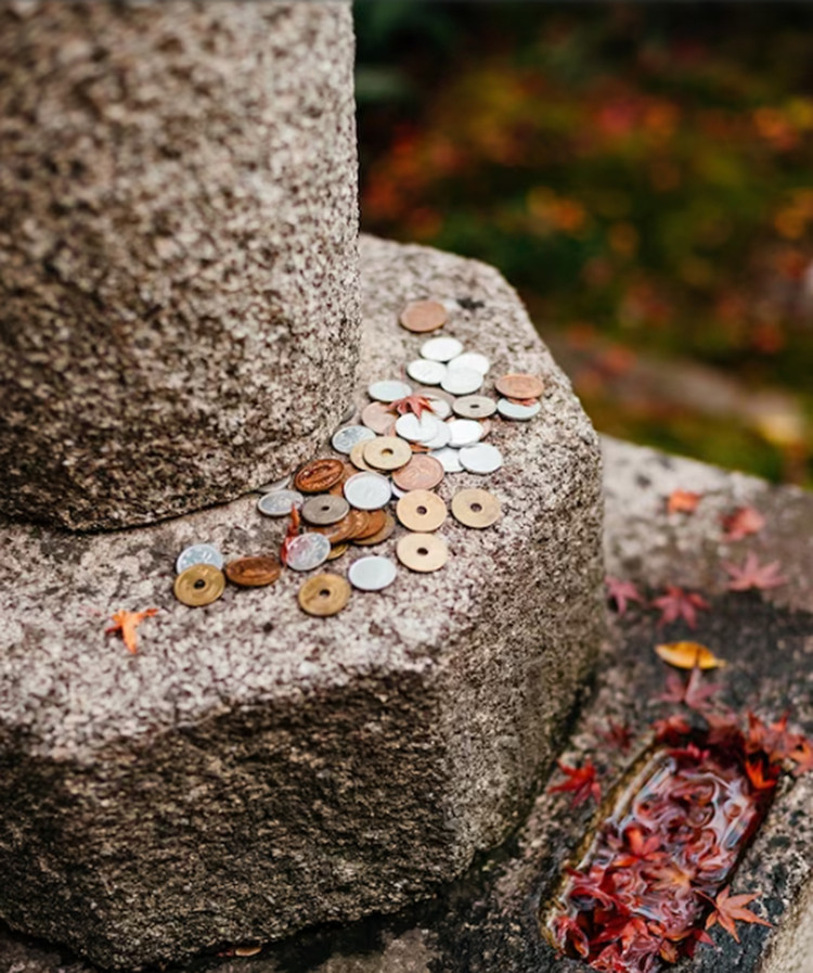 Tại ngôi chùa Phật giáo lâu đời nhất thành phố, Kennin-ji, một cột tưởng niệm rải đầy lá phong rơi và những đồng tiền vàng mã do tín đồ để lại làm lễ vật.