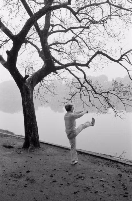Cụ ông tập thể dục bên bờ hồ Gươm, 6h sáng ngày 14/3/1990. Hình ảnh nằm trong loạt ảnh Hà Nội năm 1990 do phóng viên John Vink thuộc tổ chức nhiếp ảnh quốc tế Magnum Photos thực hiện.
