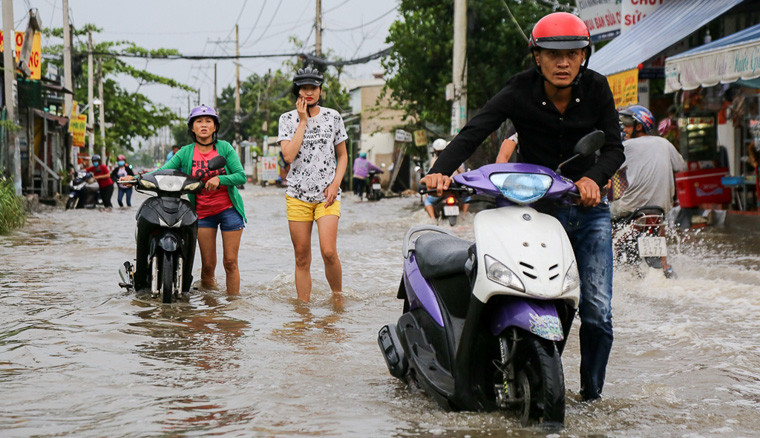 Nước dâng cao gần nửa bánh xe máy khiến nhiều phương tiện bị chết máy khi đang cố lưu thông qua dòng nước ngập trên.