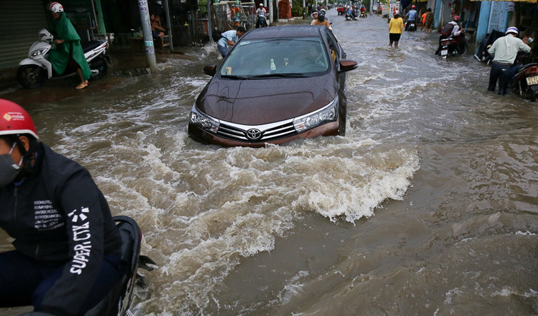 Xe cộ bì bõm lội nước qua các tuyến đường ngập nặng do ảnh hưởng triều cường.