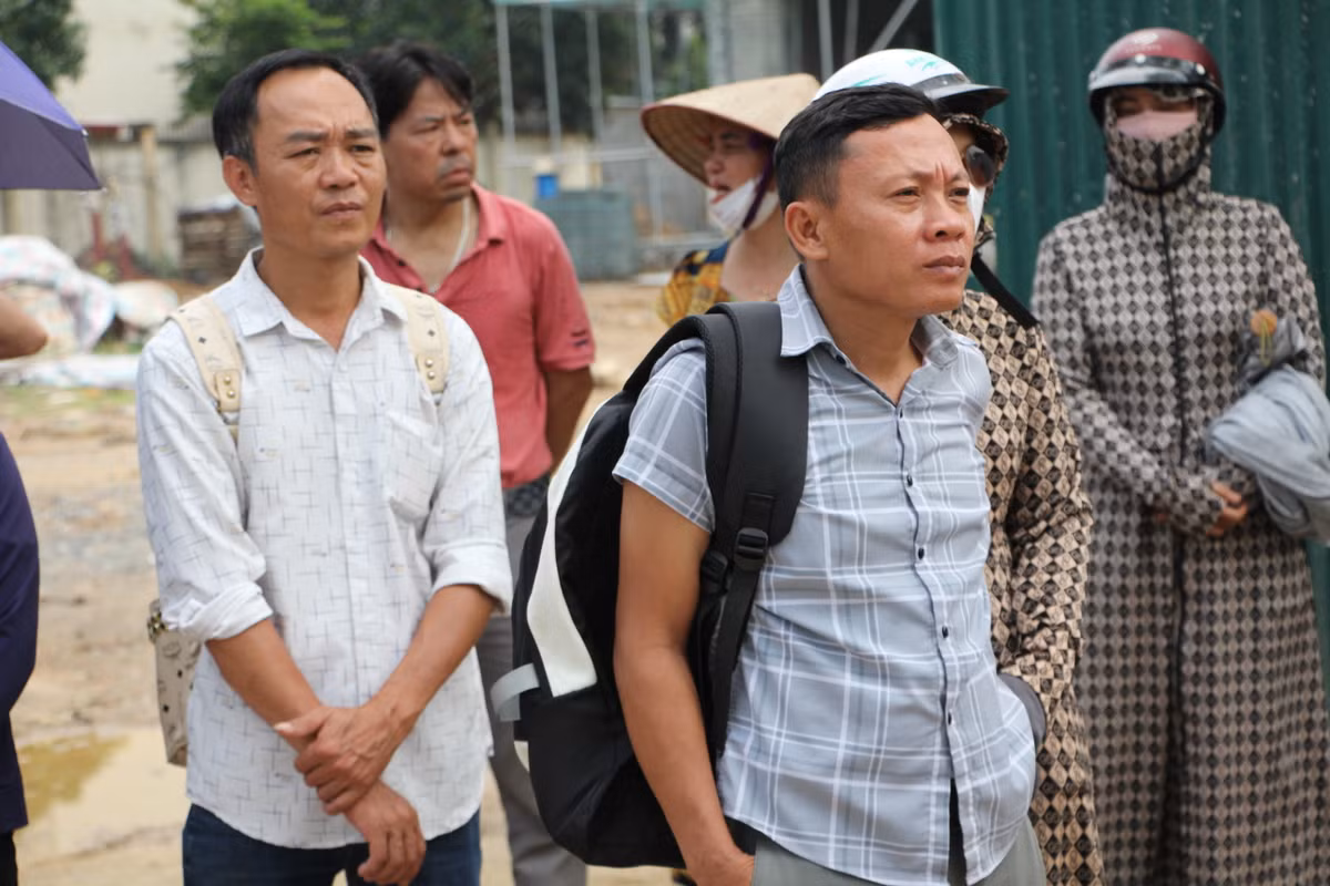 Những người bố lấm tấm mồ hôi, đeo ba lô nặng chờ đón con ở cổng trường.