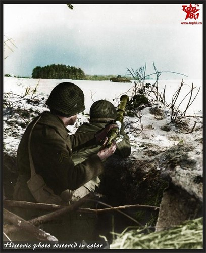 Một người lính Mỹ đang nạp đạn cho khẩu súng chống tăng Bazoka trên vai đồng đội ngắm bắn mục tiêu quân phát xít trên chiến trường châu Âu.