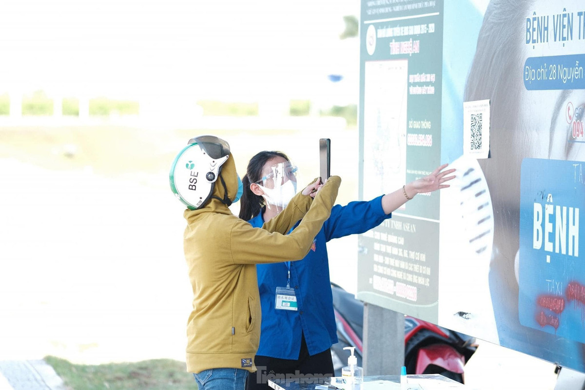 Một nữ sinh hướng dẫn người dân khai báo y tế qua app điện thoại.