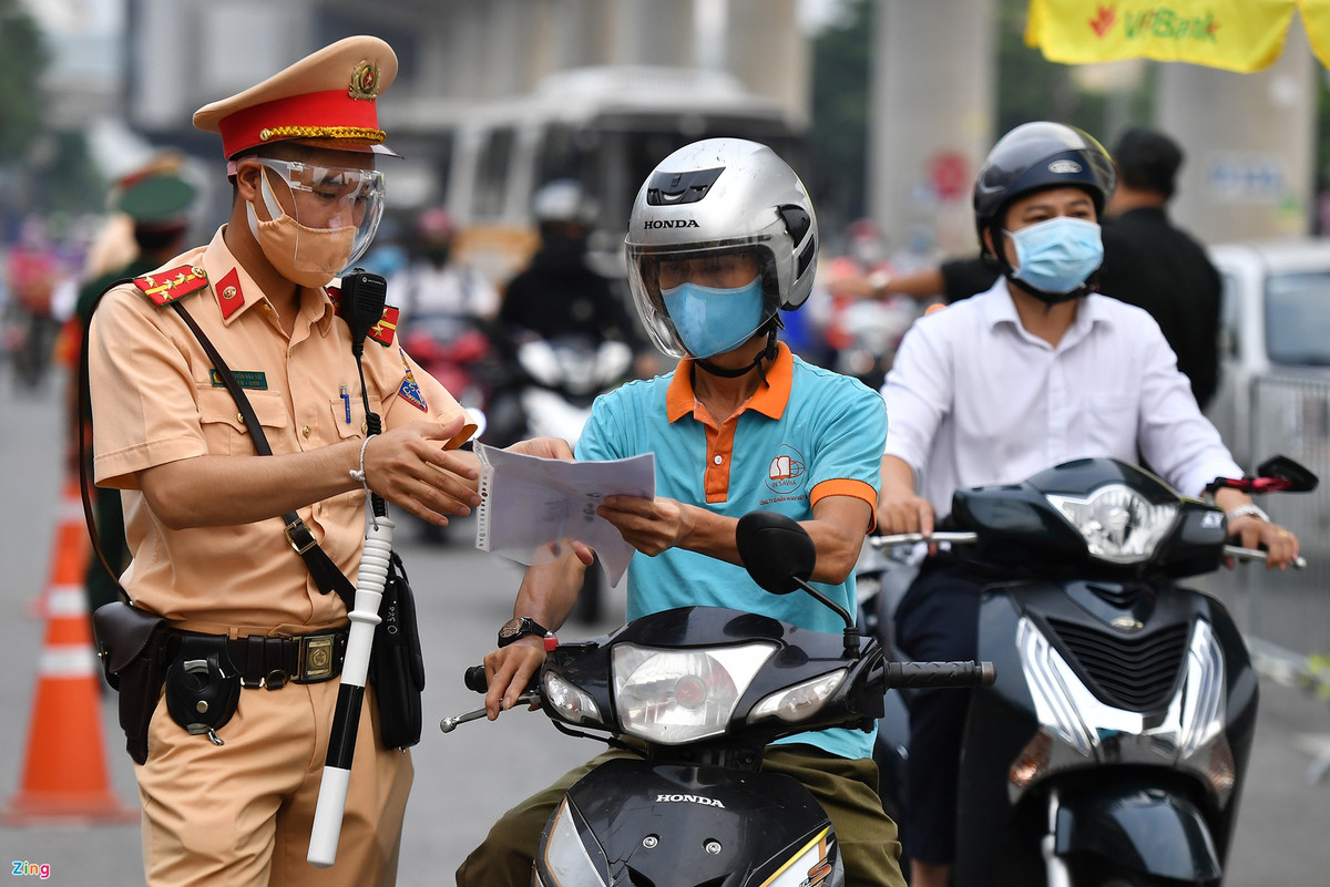Từ những người chở hàng cồng kềnh cho đến cán bộ, nhân viên văn phòng đều có giấy đi đường đầy đủ với dấu của cơ quan cấp. Trong ảnh, anh Doãn Văn Hà có địa chỉ thường trú ở huyện Phúc Thọ, còn cơ quan ở tỉnh Phú Thọ. Giấy phép của anh cho thấy được vận chuyển thực phẩm từ nhà đến khu vực Hà Nội. Ảnh: Hoàng Hà.