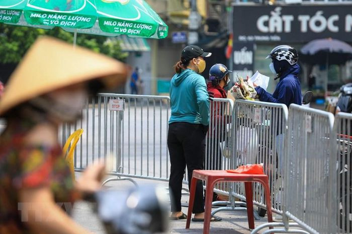 Tại chốt kiểm soát đầu ngõ Văn Chương, người dân ra, vào cần có các giấy tờ theo quy định như giấy đi đường, giấy tờ cá nhân. (Ảnh: Thành Đạt/TTXVN)