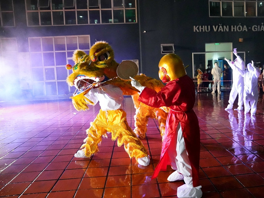 Ngày mai là đến Tết Trung thu, từ trong tâm dịch, Đại úy QNCN Vũ Thị Hậu đã gửi thư để động viên hai con Đỗ Minh Anh, Đỗ Minh Trí. (Ảnh: Đại úy QNCN Vũ Thị Hậu (áo đỏ) trong vai ông Địa biểu diễn tại chương trình. Báo QĐND)