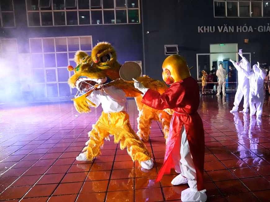 Ngày mai là đến Tết Trung thu, từ trong tâm dịch, Đại úy QNCN Vũ Thị Hậu đã gửi thư để động viên hai con Đỗ Minh Anh, Đỗ Minh Trí. (Ảnh: Đại úy QNCN Vũ Thị Hậu (áo đỏ) trong vai ông Địa biểu diễn tại chương trình. Báo QĐND)