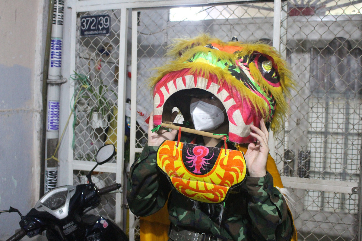 Đồng chí Nguyễn Hoàng Thiện, bộ đội thuộc Trung đoàn 88, Sư đoàn 302, Quân Khu 7, trình diễn những màn múa Lân rộn rã. “Đây là lần đầu tiên tôi làm như thế nên không biết múa sao cho đúng, cứ thấy nhạc bật lên, "ông Địa" nhảy là nhún theo thôi", Thiện (18 tuổi) bộc bạch. (Ảnh: Thanh niên)