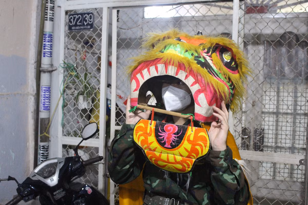 Đồng chí Nguyễn Hoàng Thiện, bộ đội thuộc Trung đoàn 88, Sư đoàn 302, Quân Khu 7, trình diễn những màn múa Lân rộn rã. “Đây là lần đầu tiên tôi làm như thế nên không biết múa sao cho đúng, cứ thấy nhạc bật lên, "ông Địa" nhảy là nhún theo thôi", Thiện (18 tuổi) bộc bạch. (Ảnh: Thanh niên)