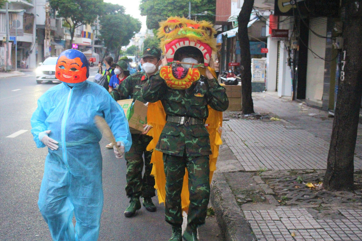 Bộ đội múa lân và tình nguyện viên chống dịch độn bụng làm "ông Địa" để mang lại niềm vui cho trẻ em dịp Tết Trung thu tại một địa phương ở TPHCM. (Ảnh: báo Thanh niên)