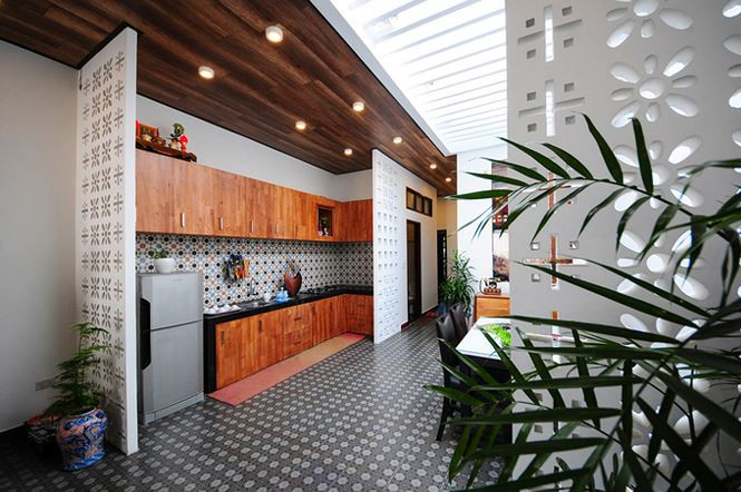 Hệ tủ bếp dài, tận dụng tối đa cả khoảng không bên trên và bên dưới bếp. Gạch ốp hoa văn ở bếp làm nổi bật, khiến không gian thêm sinh động hơn.