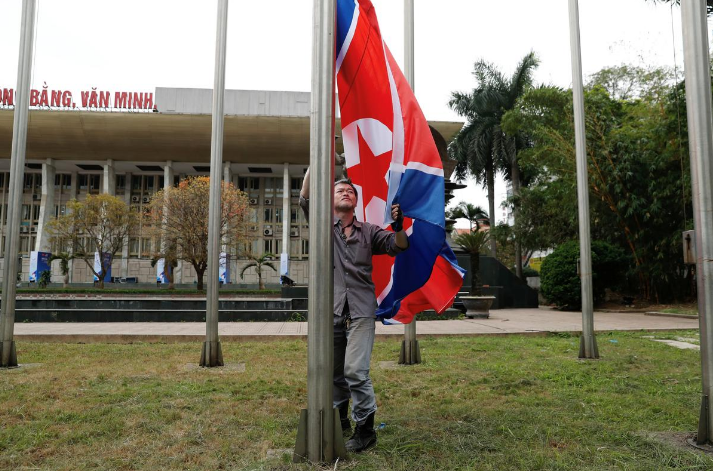 Một công nhân đang treo quốc kỳ Triều Tiên bên ngoài một trung tâm báo chí ngày 24/2 trước thềm Hội nghị Thượng đỉnh Mỹ-Triều tại Hà Nội. Ảnh: Reuters.