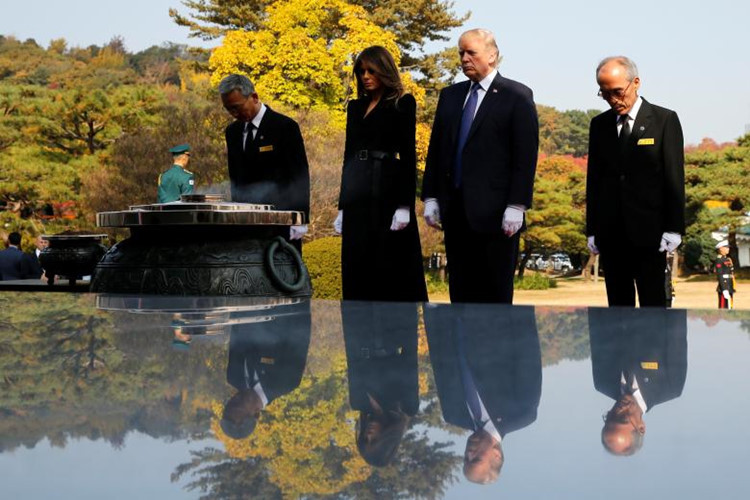 Tổng thống Trump và phu nhân Melania đặt hoa tưởng niệm tại Nghĩa trang Quốc gia ở thủ đô Seoul, Hàn Quốc. Ảnh: Reuters.