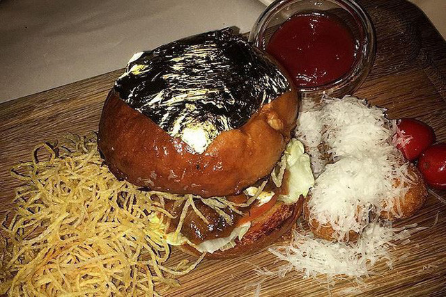 Bánh kẹp phủ vàng: Nhà hàng Italy có tên 24 Karat, nằm trong khách sạn Marriott của Dubai chuyên phục vụ các món ăn mạ vàng như bánh pizza, bánh mì kẹp burger, món rau salad trộn vàng... với giá đắt đỏ. Bánh kẹp phủ vàng được tạo nên từ các nguyên liệu tươi ngon nhất gồm thịt bò, cà chua, bánh mì tươi và lá vàng 24K. Ảnh: World News Daily.