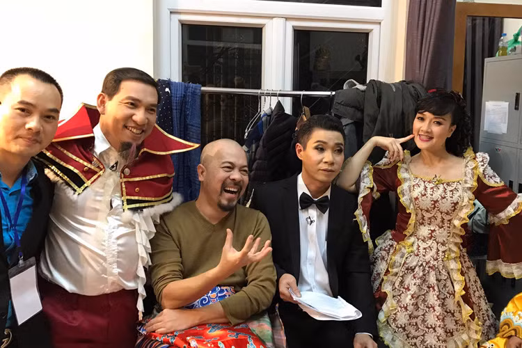 Ở hậu trường, nam thiết kế vui vẻ chụp hình kỷ niệm cùng "Táo" Vân Dung và "Táo" Quang Thắng trong trang phục quý tộc phương Tây. (Ảnh: Facebook Hat Lu Lu)