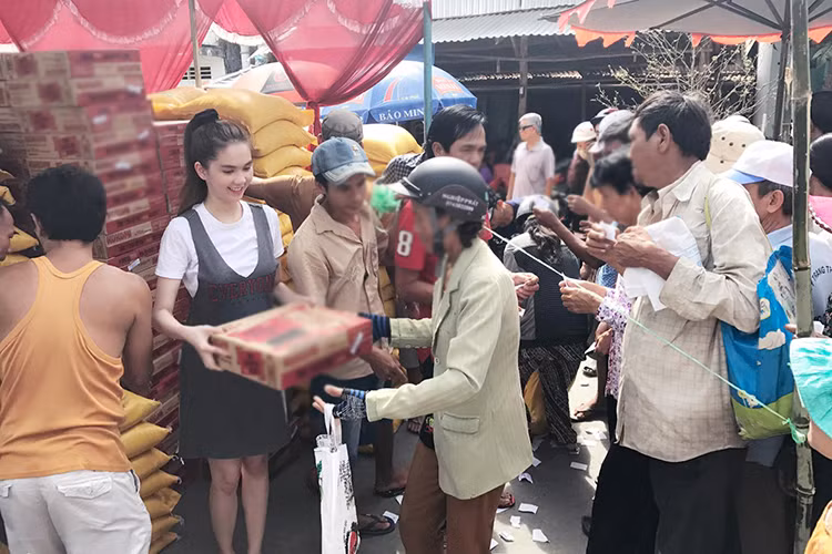 Cách đây ít giờ, trên trang cá nhân, Ngọc Trinh chia sẻ hình ảnh về quê Trà Vinh để làm từ thiện. Dù đang vướng lùm xùm đấu giá SIM nhưng cô vẫn rất vui vẻ phát gạo cho bà con nghèo. (Ảnh: Facebook nhân vật)